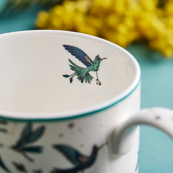 1 | Detail of the Zambezi Mug designed by Emma J Shipley, crafted in fine bone china by skilled artisans in Stoke on Trent UK, hand decorated with an exquisitely detailed and colourful design featuring leopard spotted elephants, a leaping gazelle, soaring hornbills in layers of teal, greens and neutrals, part of the Fine China Dining collection