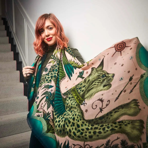 Pink | Photo of Emma next to staircase wearing Lynx Fine Wool Scarf in Pink, designed by Emma J Shipley in London featuring two winged Lynx amongst foliage