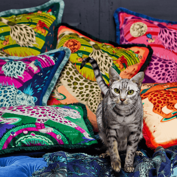 Flame | The Snow Leopard Luxury Velvet Cushion in Flame, featuring vibrant oranges, flame reds and striking blues with opulent ruche fringing. Designed by Emma J Shipley, inspired by Dante’s Inferno and Paradiso from the 14th century and Ingmar Bergman’s film “The Seventh Seal”