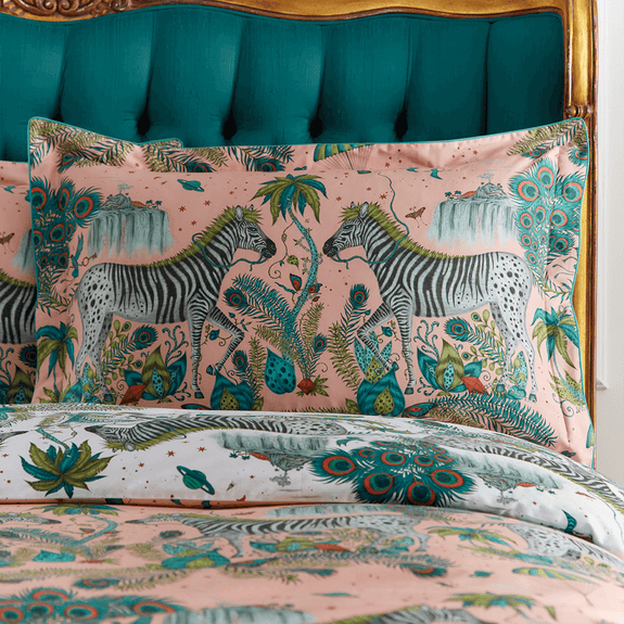 Pink/White | Transform your bedroom into a surreal African landscape with the Lost World Oxford Pillowcase in pink/white, designed by Emma J Shipley. Featuring a striking scene of creatures including  Peacock tailed Zebras, Palm trees and parachutes.