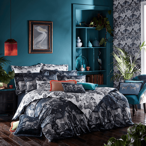 Navy/White | Transform your bedroom into a surreal African landscape with the Lost World Duvet Cover in navy, designed by Emma J Shipley. Featuring a striking scene of creatures including striking Peacock tailed Zebras, Palm trees and parachutes.