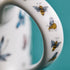 1 | Bees on the handle of the Kruger Mug designed by Emma J Shipley, crafted in fine bone china by skilled artisans in Stoke on Trent UK, hand decorated with an exquisitely detailed and colourful artwork with giraffes and detailed foliage in yellow, blues and greens - part of the Fine China Dining collection