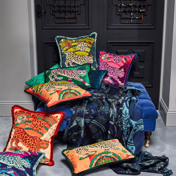 Flame | The Snow Leopard Luxury Velvet Cushion in Flame, featuring vibrant oranges, flame reds and striking blues with opulent ruche fringing. Designed by Emma J Shipley, inspired by Dante’s Inferno and Paradiso from the 14th century and Ingmar Bergman’s film “The Seventh Seal”