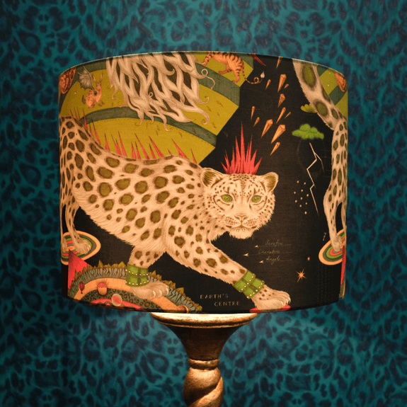 A lifestyle shot of the Snow Leopard Lampshade by Emma J Shipley shows the glow of the deep teal and the soft lime green and the soft brown