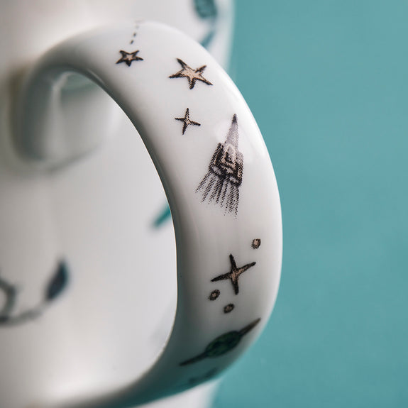 1 | Detail of the Zambezi Mug handle designed by Emma J Shipley, crafted in fine bone china by skilled artisans in Stoke on Trent UK, hand decorated with an exquisitely detailed and colourful design featuring leopard spotted elephants, a leaping gazelle, soaring hornbills in layers of teal, greens and neutrals, part of the Fine China Dining collection